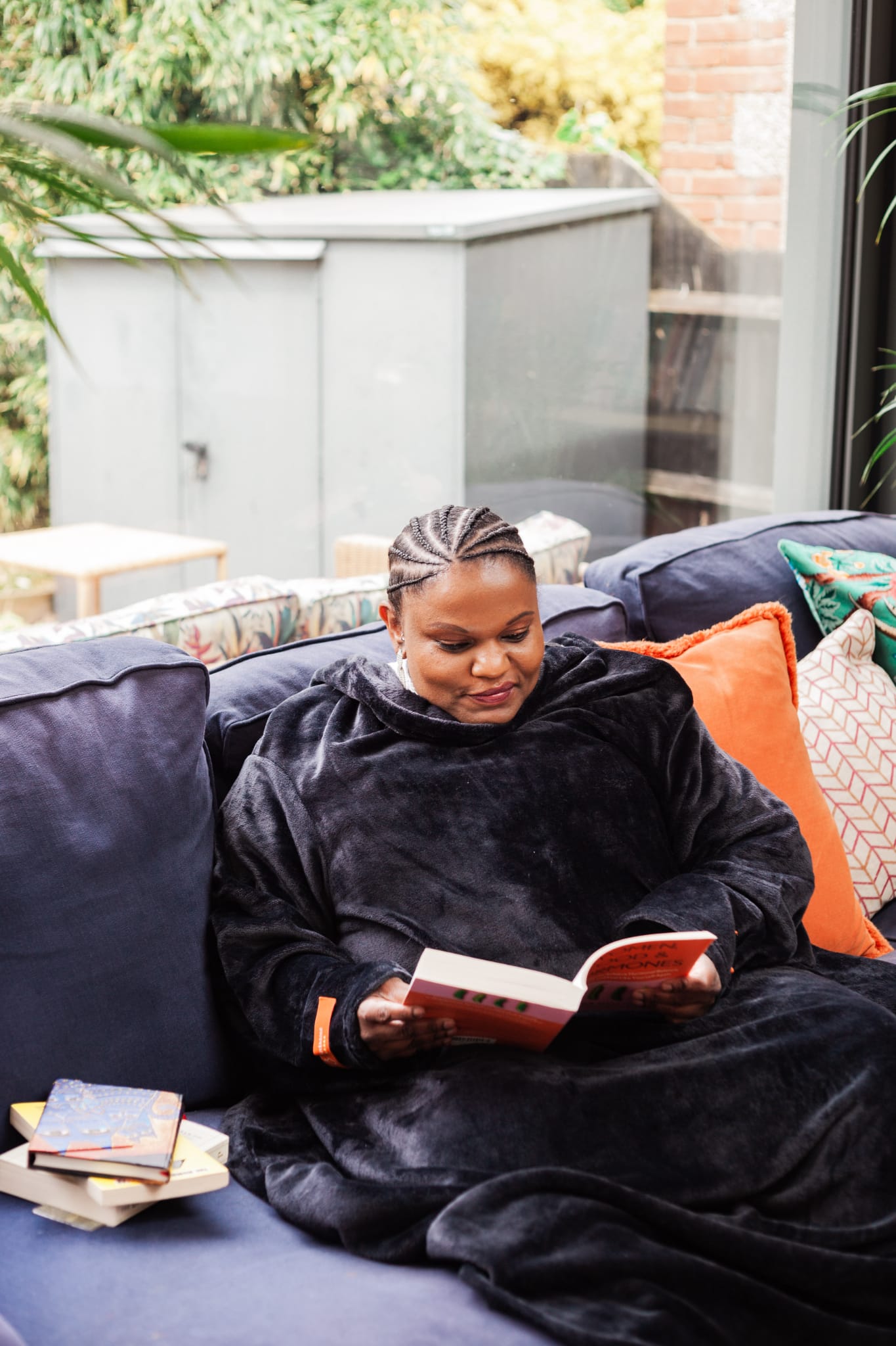 Woman sitting on a couch reading a book